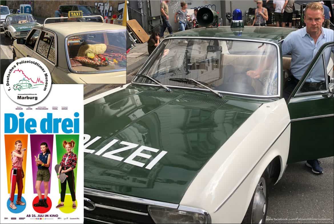 Ein Bild mit Plakat zum Kinofilm "Die drei Ausrufezeichen" mit dem Polizeioldtimer und Schauspieler Hinnerk Schönemann