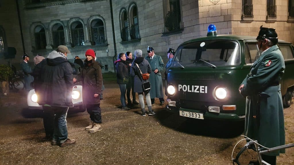 Die Szene im Innenhof mit Regisseurin Mira Thiel und den Polizeioldies aus Marburg - samt Polizeikomparsen, rechts Klaus Karwatzki