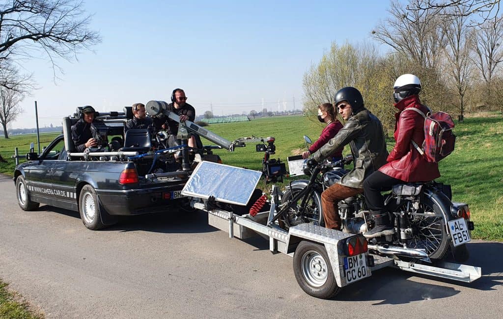 Für den Dreh der Anfahrt zur Verkehrskontrolle mit dem Motorrad wurde ein Spezialfahrzeug mit Hänger genutzt, auf dem das Motorrad befestigt war, das Kamera-Team befindet sich auf dem umgebauten BMW