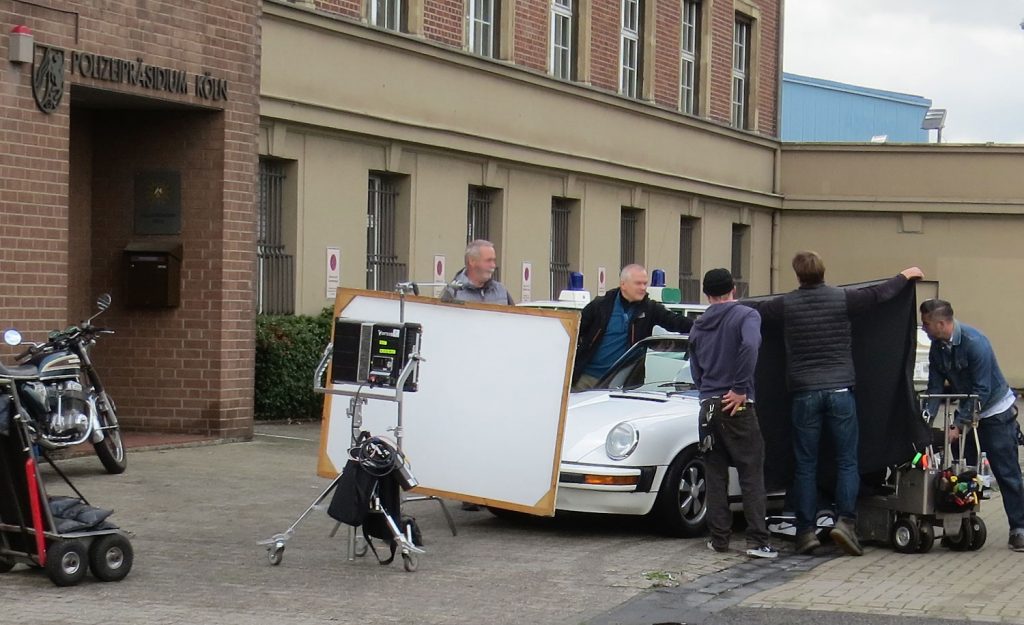 Die historischen Polizeifahrzeuge aus dem Polizeioldtimer Museum Marburg stehen im Hintergrund beim Dreh zum RTL-Film "Entführt - 14 Tage Überleben" vor dem Polizeipräsidium Köln