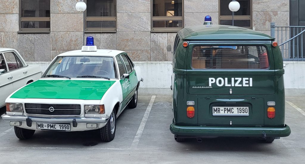Die Filmfahrzeuge für den Dreh von Ku'damm 77 im Hinterhof der fiktiven Polizeidirektion, rechts der VW T2 und daneben der Opel Rekord D aus dem Polizeioldtimer Museum Marburg, noch ohne Filmkennzeichen
