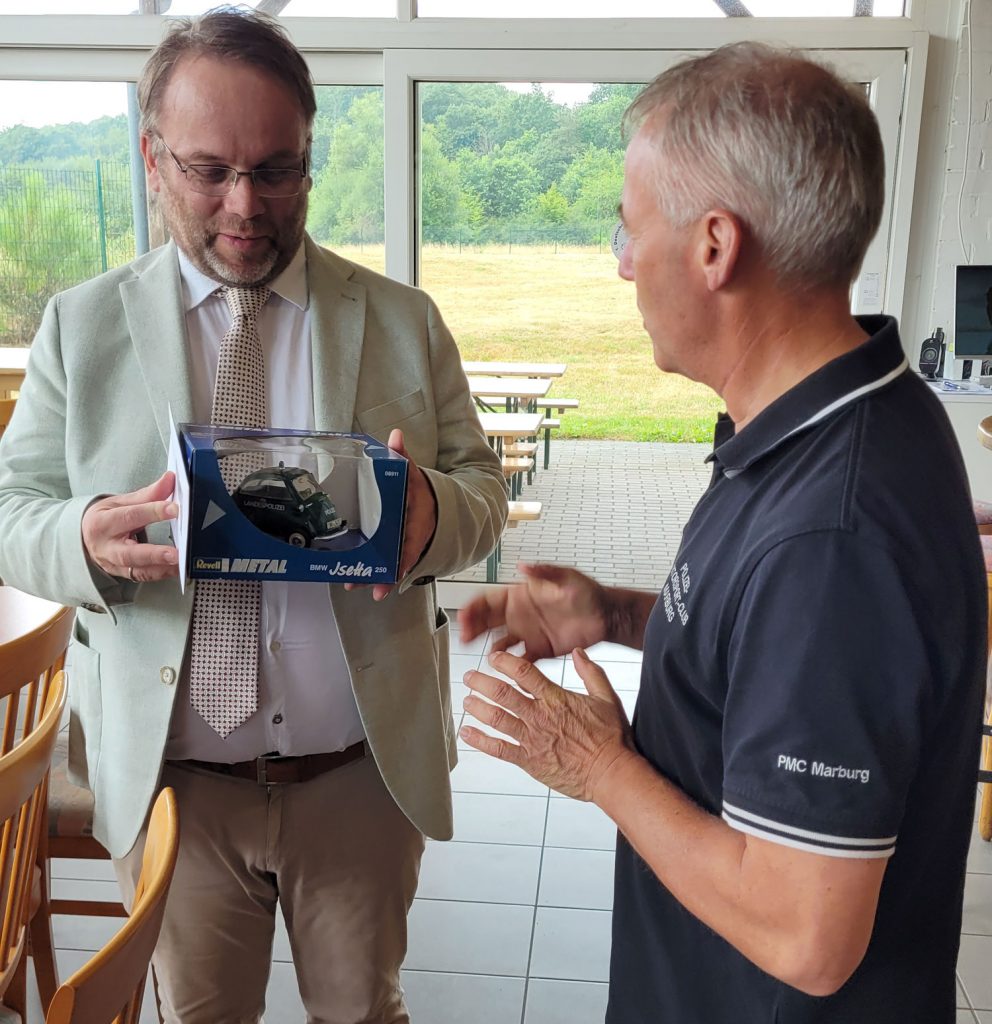 Minister Timon Gremmels erhält zum Abschied vom PMC-Vorsitzenden Frank Dönges ein Modell eines Polizeioldtimer überreicht