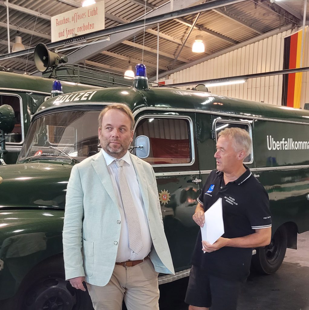v.l. Kunst- und Kulturminister Timon Gremmels beim Rundgang mit dem PMC-Vorsitzenden Frank Dönges durch das Polizeioldtimer Museum Marburg