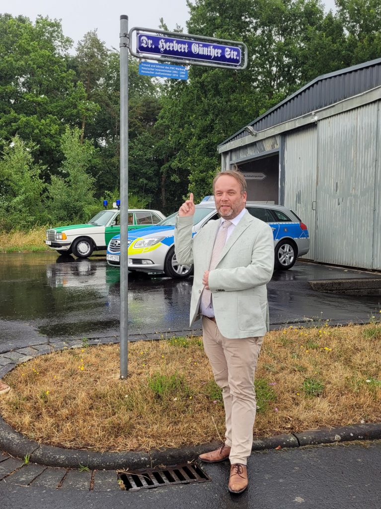 Ein Foto unter dem Straßenschild vom ehem. hessischen Innenminister Dr. Herbert Günther (einer der ersten Unterstützter des PMC) musste dann mit Minister Timon Gremmels unbedingt im Polizeioldtimer Museum gemacht werden
