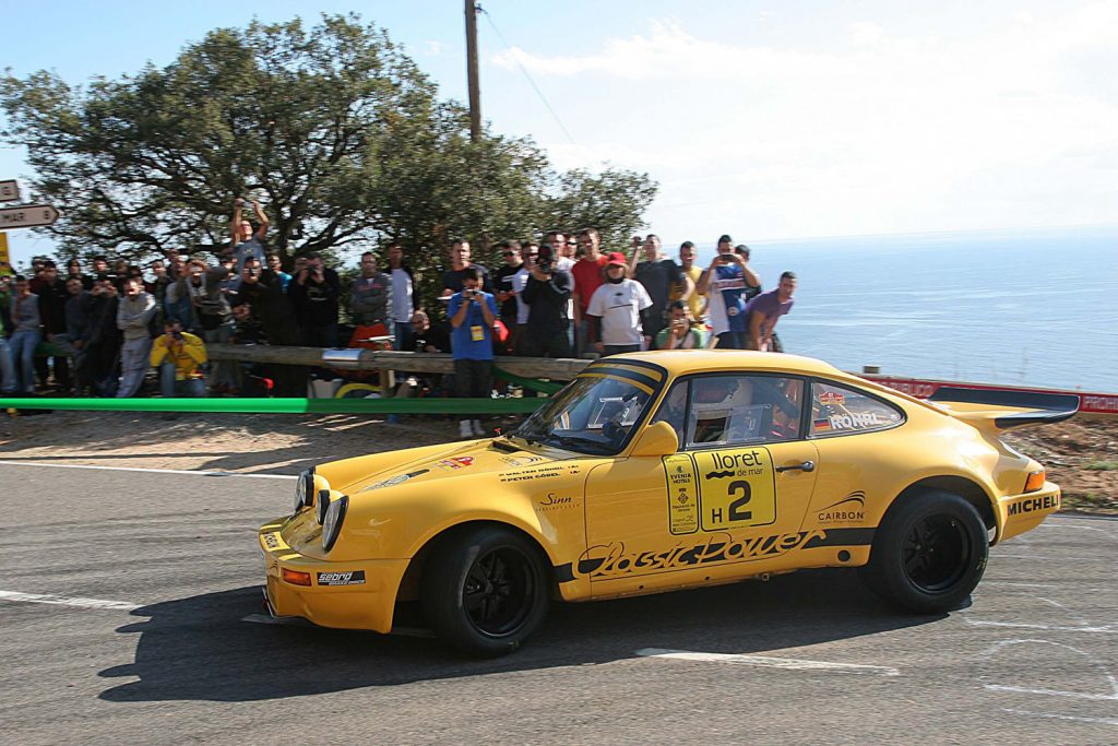 Der Porsche vom Typ 911 RSR 3.0 aus dem Jahr 1981 wird vom mehrfachen Rallye-Weltmeister Walter Röhrl gesteuert. Es ist exakt jener Wagen, mit dem Röhrl 2009 den historischen Rallye-EM-Lauf an der Costa Brava gewann. Beifahrer seinerzeit war Peter Göbel, der heute Rallyes organisiert, wie die Röhrl-Klassik